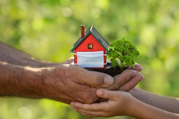 Family Holding Model House Medical Mask Hands Spring Green Blurred — Fotografia de Stock