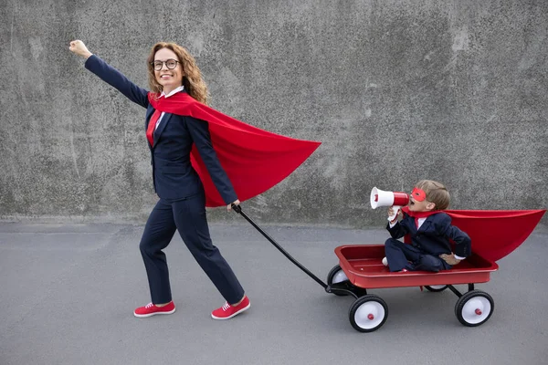 Mujer Feliz Superhéroe Trabajar Chico Súper Héroe Divertido Montando Carreta — Foto de Stock