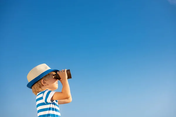 青い空に対して双眼鏡を通して見ている子供 夏に屋外で楽しい時間を過ごしている子供 冒険と旅行のコンセプト — ストック写真