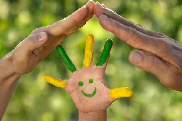 Gelukkig Kind Met Glimlach Bij Hand Tegen Groene Lente Achtergrond — Stockfoto