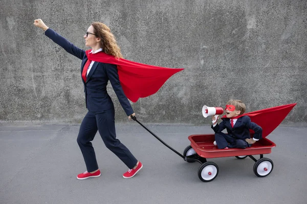 ハッピー女性のスーパーヒーローが動作するようになる レトロなワゴンに乗って面白いスーパーヒーローの子供 幸せな家庭の屋外 学校やビジネスの概念に戻る — ストック写真