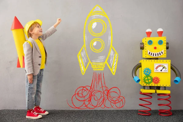 Roket ve robotlu mutlu çocuk. Evde oynayan komik çocuk. Başarı, yaratıcı ve yenilikçi teknoloji kavramı