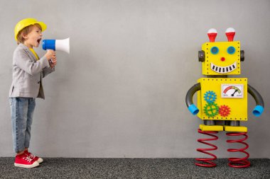 Robotlu mutlu çocuk. Evde oynayan komik çocuk. Hoparlörden bağıran çocuk. Başarı, yaratıcı ve yenilikçi teknoloji kavramı