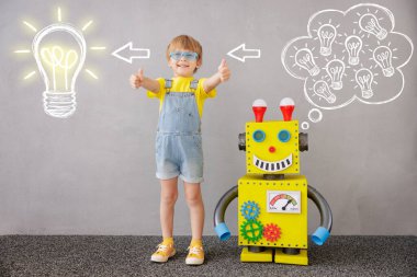 Mutlu çocuk robotla ayakta duruyor. Evde oynayan komik çocuk. Başparmak kaldıran çocuk! Başarı, yaratıcı ve yenilikçi teknoloji kavramı