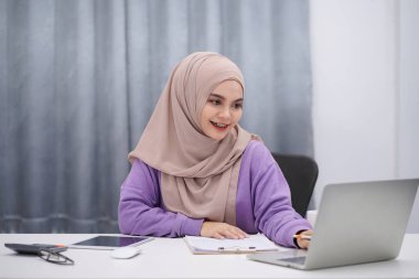 Attractive muslim woman brown hijab working at her home