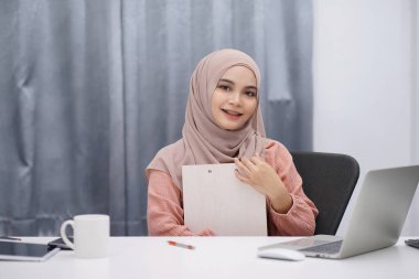 Portrait of muslim woman brown hijab working at her home