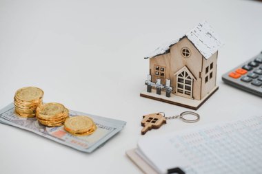 ABD Doları 'nın banknotları, model ev, kontrat anlaşmaları masanın üzerinde. Gayrimenkul, konut kredisi ve yatırım kavramı