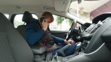 Telefonu olan adam saçlarını düzleştiriyor.