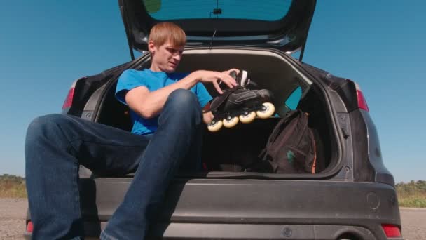Homem jovem coloca em patins de rolo — Vídeo de Stock