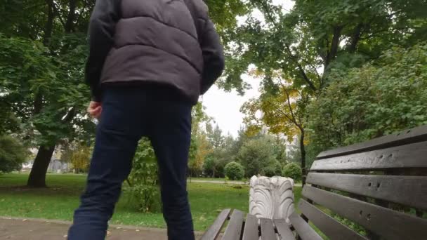 Человек сидит на скамейке — стоковое видео