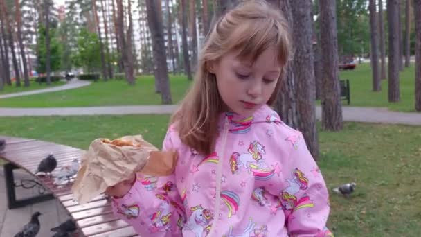 Chica comiendo y bebiendo en el parque — Vídeo de stock