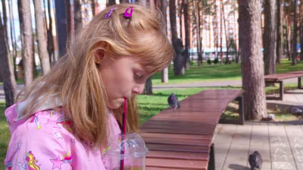 Dívka pije v parku pomalý pohyb — Stock video