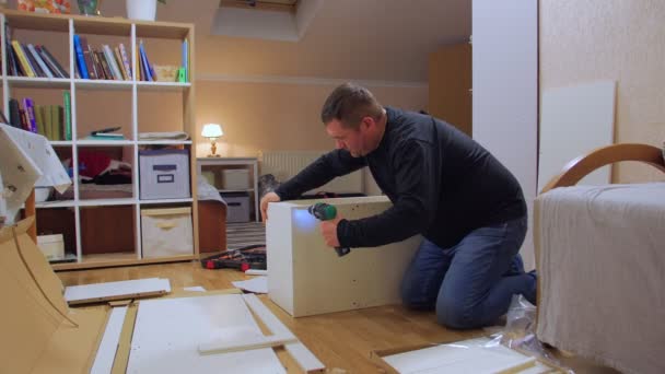 Een man met schroevendraaier monteren meubels — Stockvideo