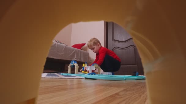 El chico está jugando con coches de carretera — Vídeos de Stock