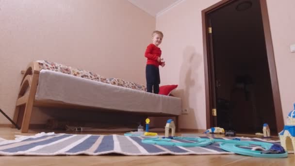 Junge springt aus dem Bett — Stockvideo