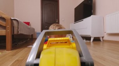 Küçük çocuk traktörle oynuyor.
