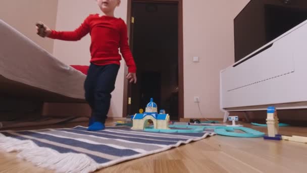 Мальчик играет с игрушечными машинами — стоковое видео