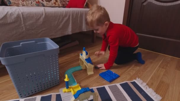 Мальчик играет в игрушечный автомобиль — стоковое видео