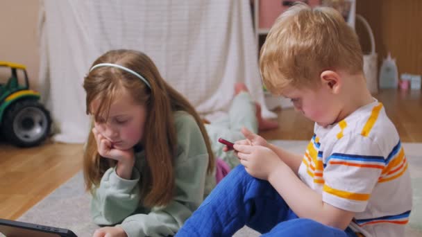 Meisje en jongen met telefoon en tablet — Stockvideo
