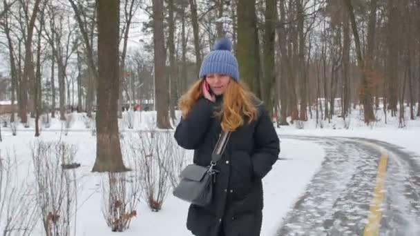 Kobieta rozmawiająca przez telefon idzie sama — Wideo stockowe