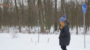 Telefonda konuşan ve yürüyen bir kadın.