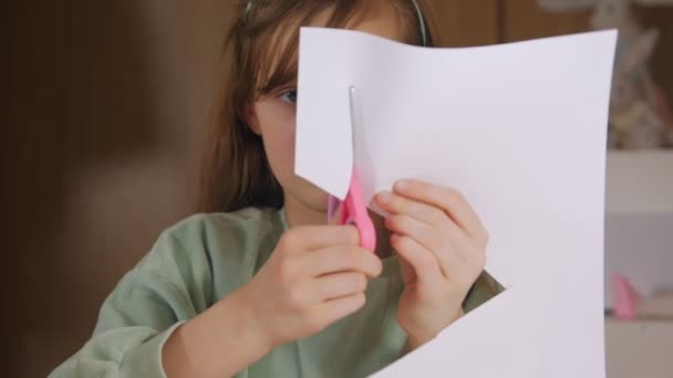 Девушка режет ножницами бумагу — стоковое видео