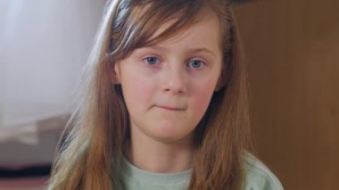 Kız kameraya bakıyor ve gülüyor