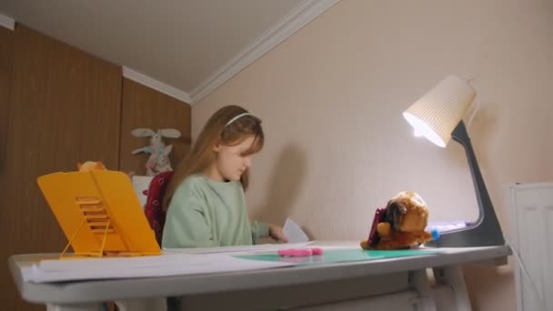 Дівчина ховає папір під столом — стокове відео
