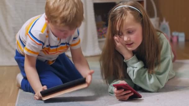 Los niños se acuestan con gadgets — Vídeos de Stock