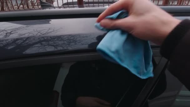 Man veegt de auto af met een doek — Stockvideo