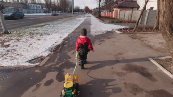 Menino andando na rua em movimento lento de inverno — Vídeo de Stock