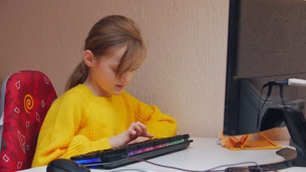 Девочка учится печатать на компьютере — стоковое видео