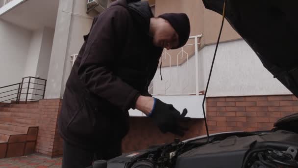 Een man controleert een auto — Stockvideo