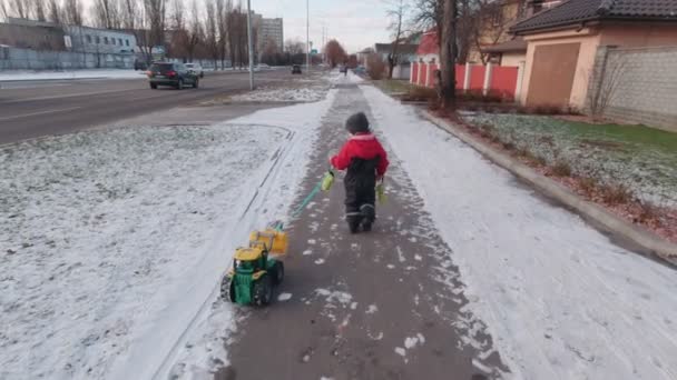 Мальчик с трактором движется медленно — стоковое видео