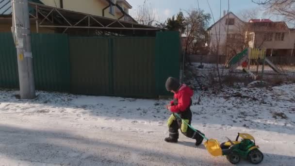 Мальчик, гуляющий в зимнем пригороде — стоковое видео