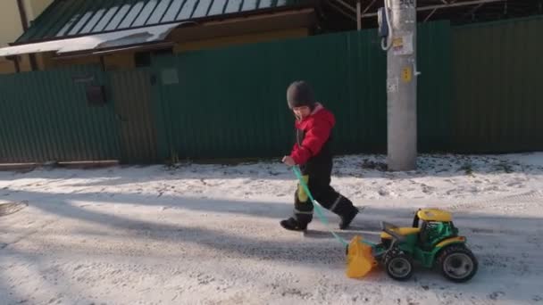Мальчик, гуляющий в зимнем пригороде — стоковое видео
