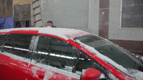 El hombre limpia el coche de la nieve — Vídeo de stock