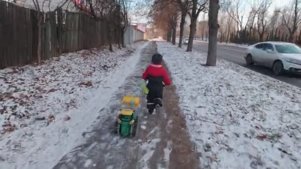 Мальчик бегает с игрушечной машиной — стоковое видео