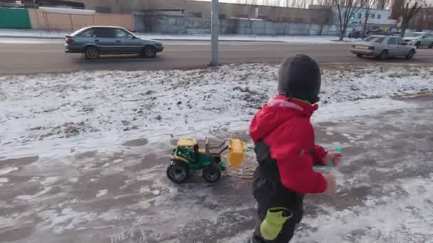 Un niño caminando por la calle en invierno — Vídeo de stock