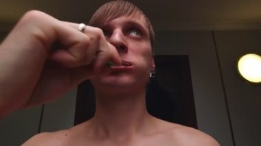 Adam dişlerini fırçalıyor.