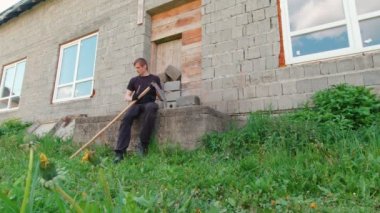Yeşil çimenleri ve evi tırmalayan bir adam.