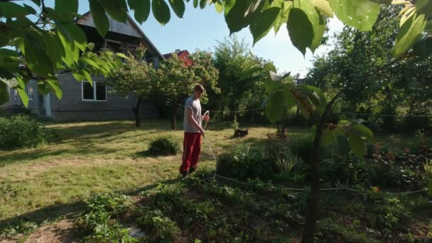 Mann Wässert Die Pflanzen Garten Laub Vordergrund — Stockvideo