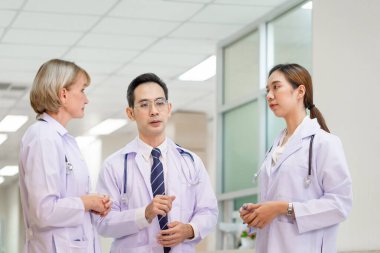 Medical team discussing in the corridor at hospital, team of mixed-races doctors, Group of multi ethnic medics, men and women talking and having discussion