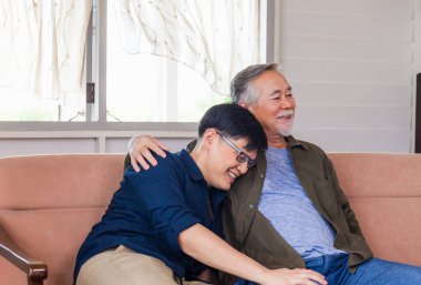 Neşeli kıdemli Asyalı baba, yetişkin oğluna tavsiye veriyor. Mutluluk aile kavramları.