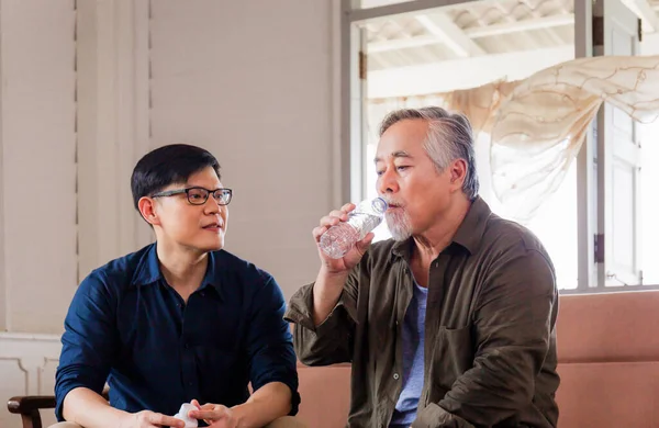 Oudere Man Drinkwater Zoon Van Middelbare Leeftijd Zorgt Voor Zieke — Stockfoto