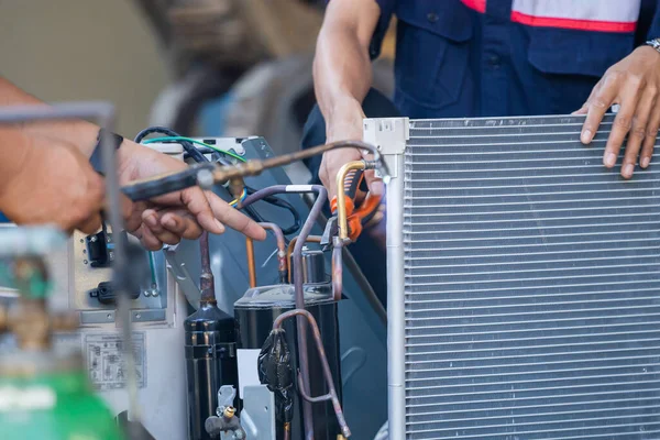 Air Conditioning Repair team use fuel gases and oxygen to weld or cut metals, Oxy-fuel welding and oxy-fuel cutting processes, repairman on the floor fixing air conditioning system
