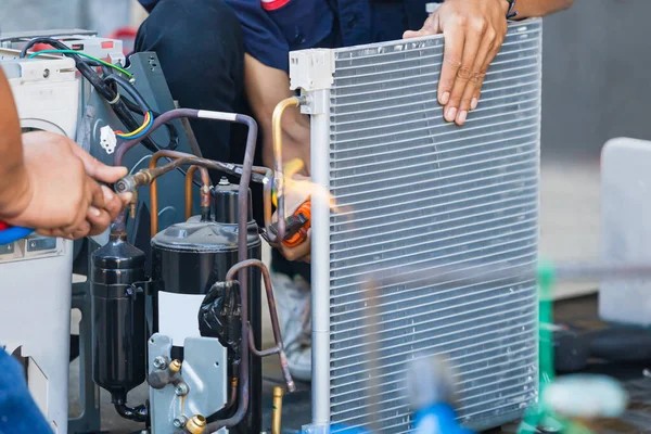 Close up of Air Conditioning Repair team use fuel gases and oxygen to weld or cut metals, Oxy-fuel welding and oxy-fuel cutting processes, repairman on the floor fixing air conditioning system