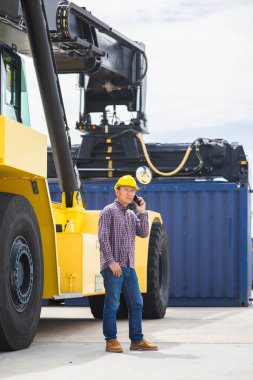 Kargo konteynerlerindeki iş adamının portresi, iş yerindeki akıllı telefonu kullanarak ustabaşı mühendis ihracat özel lojistik kargo terminali endüstrisi ithal ediyor.