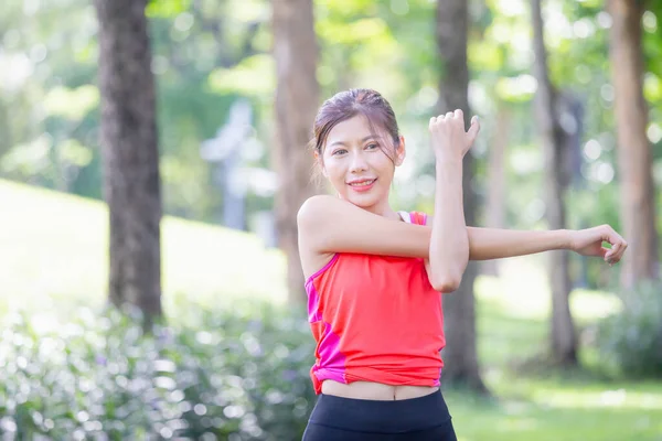 健康女性在运动前伸展肌肉 女性在公园晨练时伸展肌肉 年轻女性在运动前伸展双手 准备跑步 — 图库照片