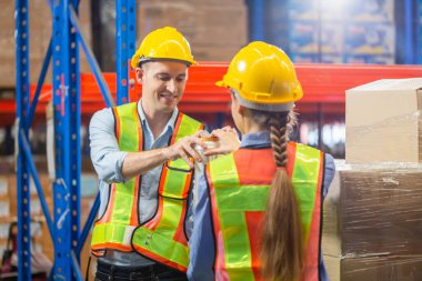 Seçici odak çalışanı ekibi depoda streç film kutularını paketliyor, işçiler fabrika deposundaki palette streç film paketlerini paketliyor.